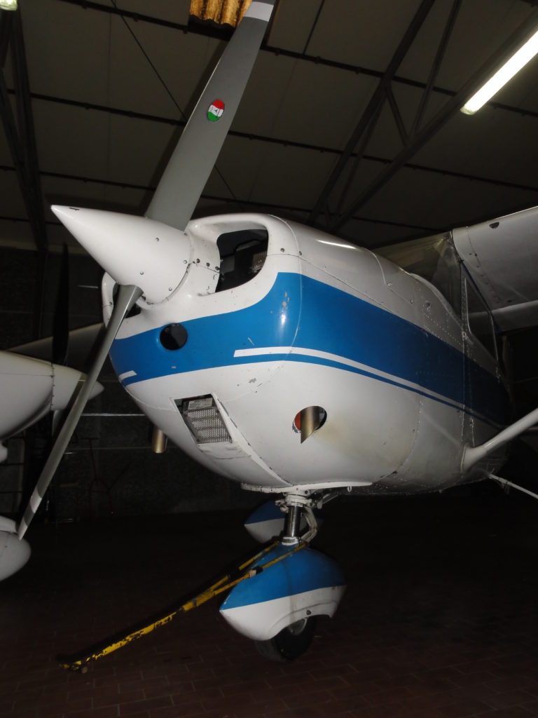 Small blue and white aircraft in hangar