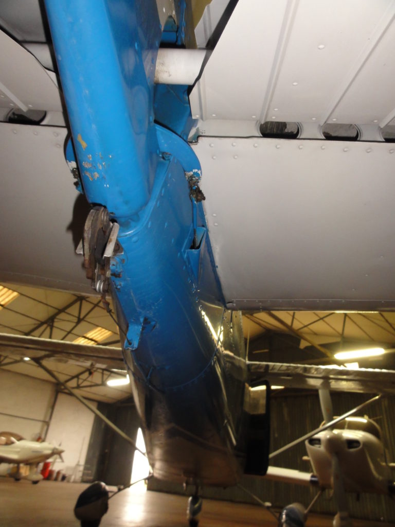 Underside view of aircraft wing in hangar.