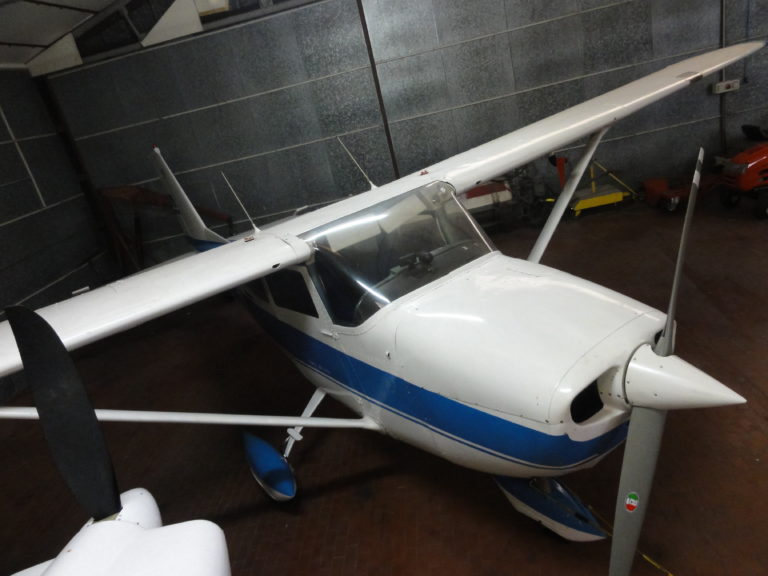 Light aircraft parked in a hangar, overhead view.
