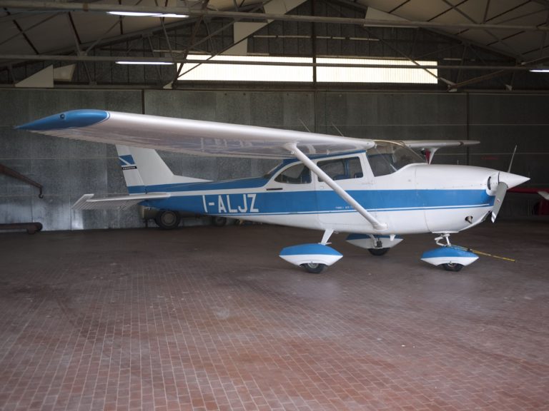 Blue and white airplane inside a hanger.