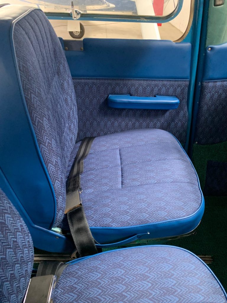 Blue airplane seat with seatbelt.