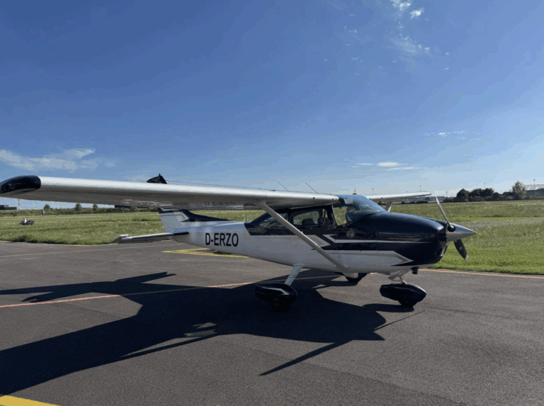 Small aircraft parked on sunny airport runway