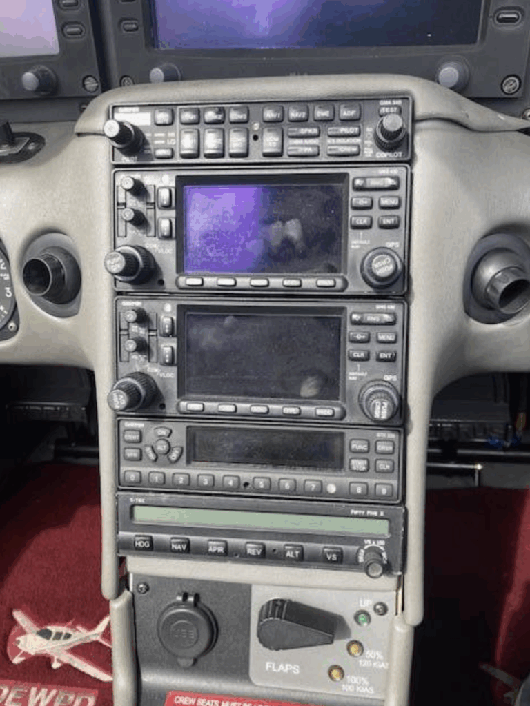 Aircraft cockpit control panel with navigation instruments.