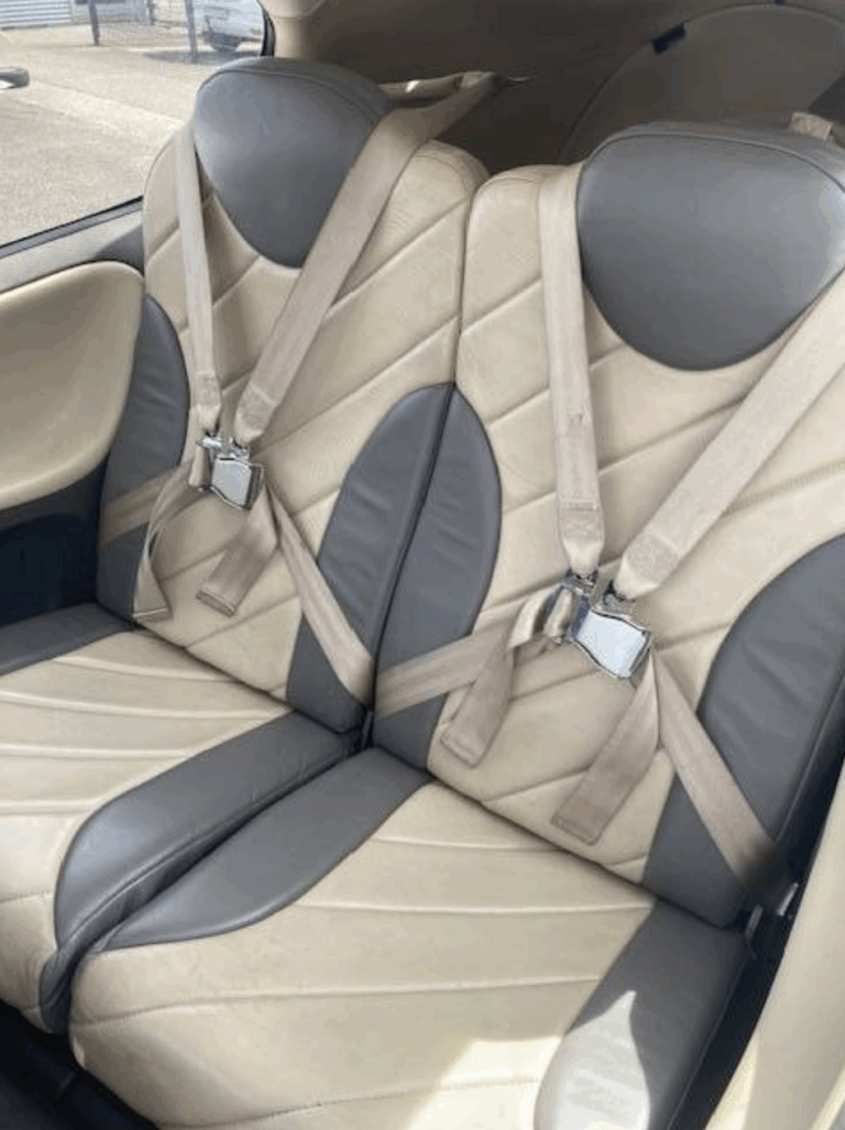 Beige and gray car seats with seatbelts installed.