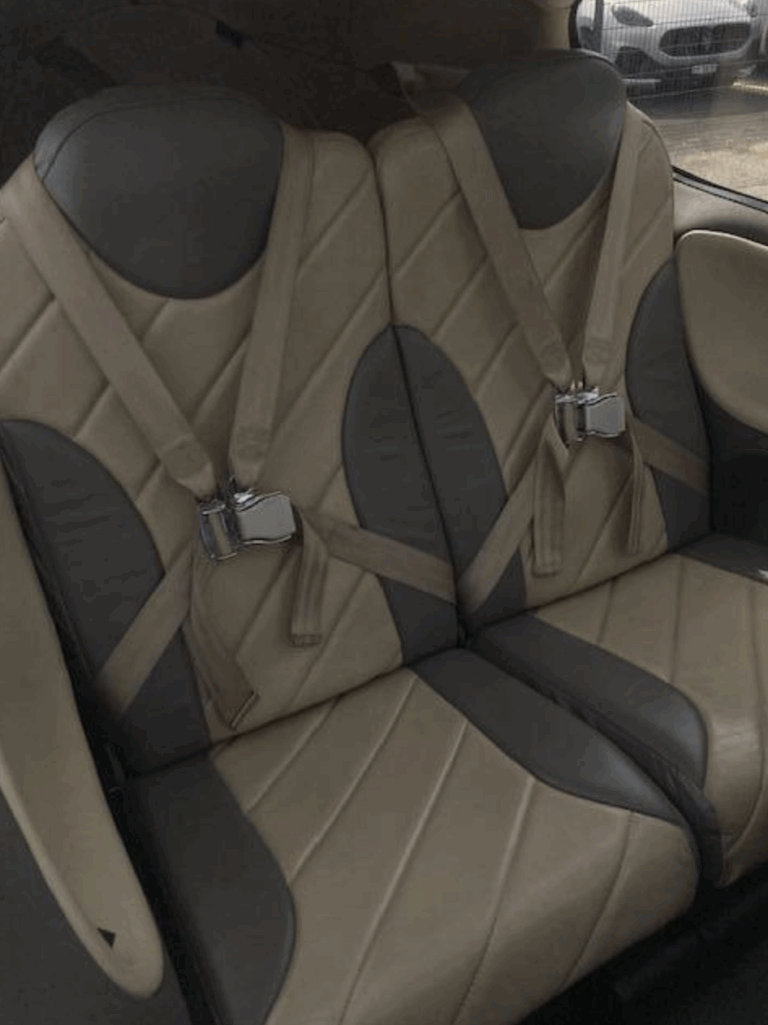 Two leather car seats with seatbelts
