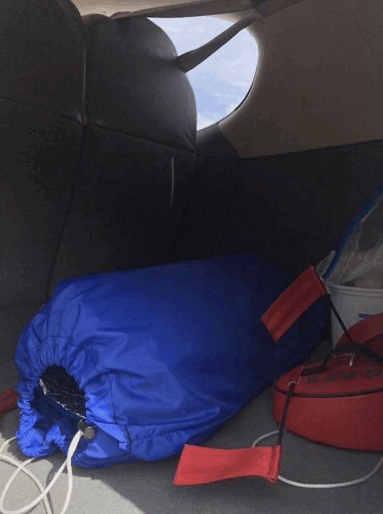 Blue bundle in car trunk with red straps