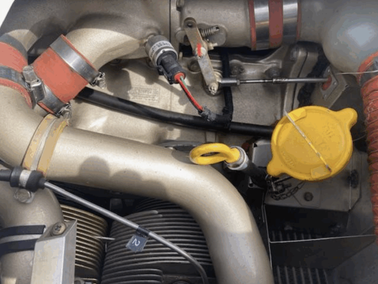 Aircraft engine with various cables and parts visible.